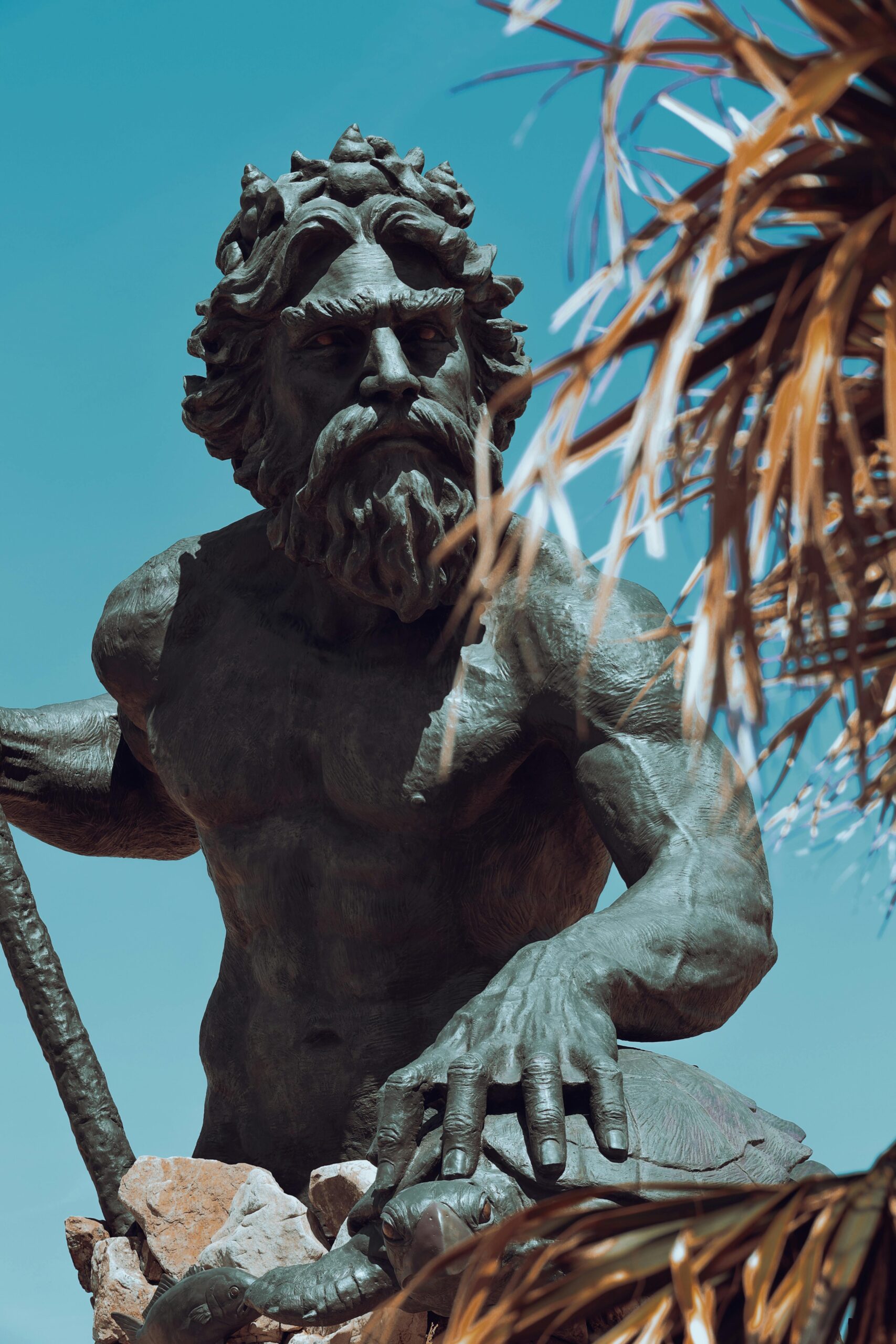 Close-up of the bronze Neptune statue against a clear blue sky in Virginia Beach, USA.